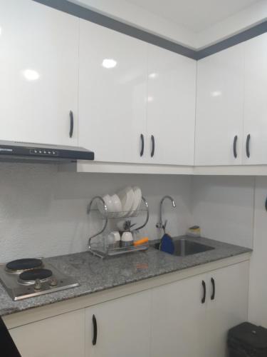 a kitchen counter with a sink and white cabinets at Cagayan de Oro City Transient Near Polymidec Medical Plaza in Cagayan de Oro