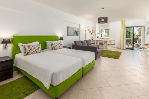 a bedroom with a large bed and a living room at Estudios Salinas - Fuseta in Fuzeta