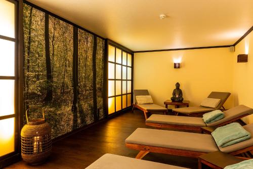 a room with several tables and chairs and windows at MUNTE - Wellnesshotel am Stadtwald in Bremen
