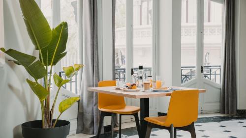 un comedor con mesa, sillas y una planta en One Shot Reina Victoria, en Valencia