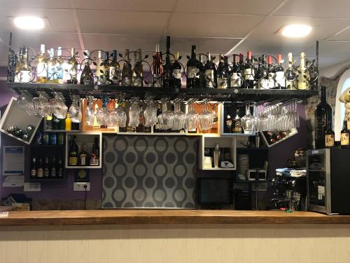 a bar with a lot of bottles and glasses at Villa Palatina in Bolgues