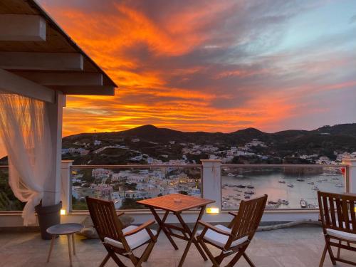 a table and chairs on a balcony with a sunset at Domus Ɫ Ponza SeaView in Ponza