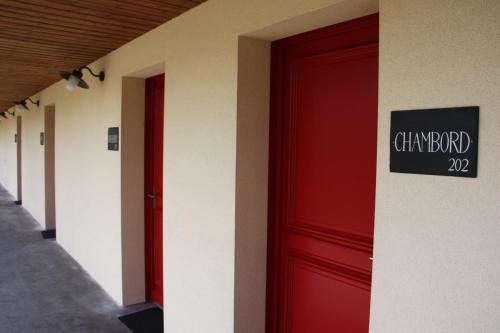 a row of red doors in a hallway at Loire & Sens in Juigné-sur-Loire