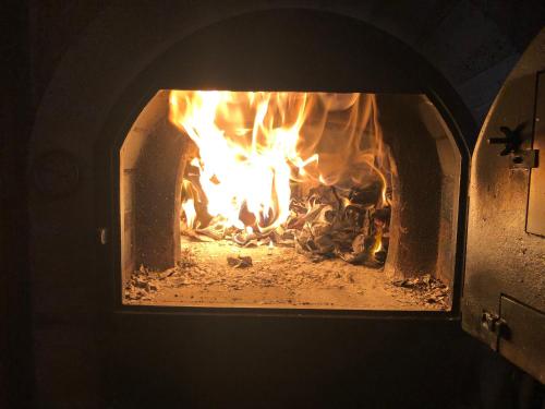 a fire in a brick oven with flames in it at Villa Palatina in Bolgues