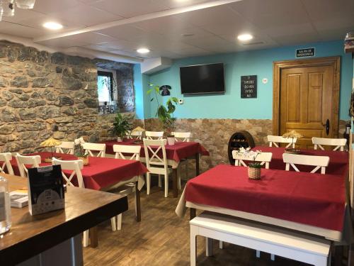 a restaurant with tables and chairs and a stone wall at Villa Palatina in Bolgues