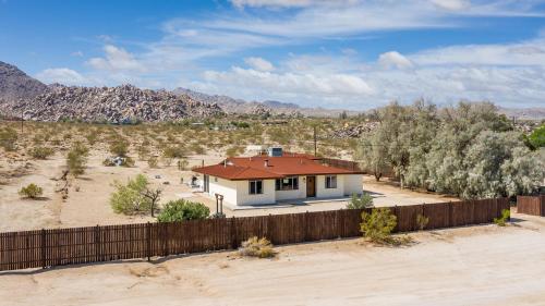 a house in the desert with a fence at @ Marbella Lane - The Moon Designer Home right behind the JTNP in Joshua Tree