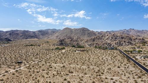 an aerial view of the desert with mountains in the background at @ Marbella Lane - The Moon Designer Home right behind the JTNP in Joshua Tree