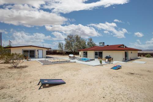 a house in the middle of a dirt field at @ Marbella Lane - The Moon Designer Home right behind the JTNP in Joshua Tree