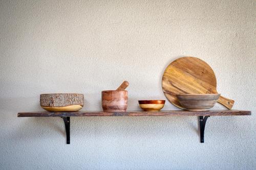 a shelf with bowls and a wooden plate on it at @ Marbella Lane - The Moon Designer Home right behind the JTNP in Joshua Tree