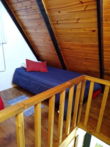 Cama en habitación con techo de madera en 7 esencias en Villa Yacanto