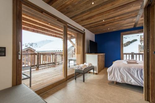 - une chambre avec un lit et une grande fenêtre dans l'établissement CAPRICORNE - Chalet sur les pistes avec sauna et home cinema, à La Toussuire