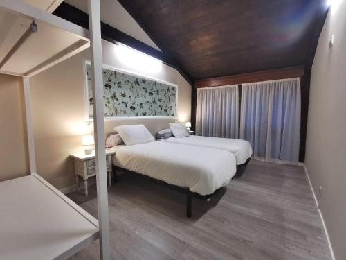 1 dormitorio con 2 camas y un cuadro en la pared en Apartamentos rurales Casa Gorrión - Mazaricos, en Sanfoga