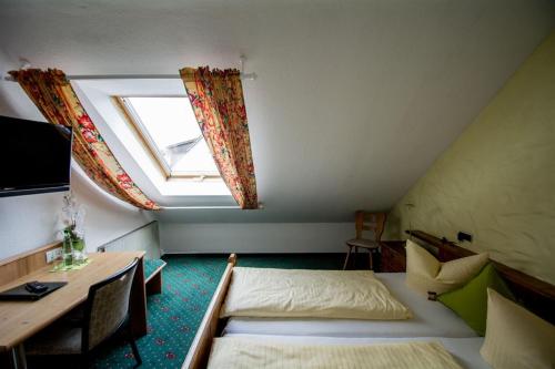 Habitación con cama, escritorio y ventana. en Hotel Avenue Altenfurt en Núremberg