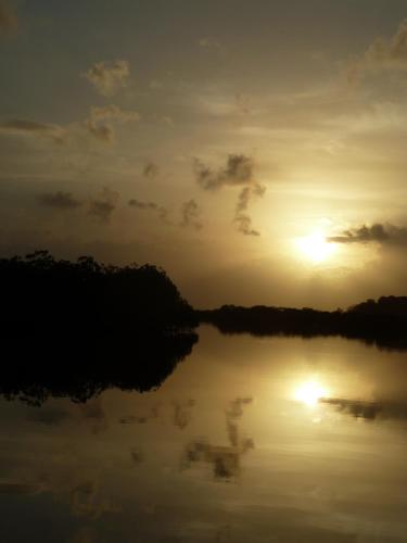 a sunset over a lake with the sun setting at Villa F&B in Bocas del Toro