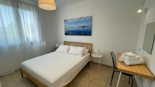 a bedroom with a bed and a table and a desk at Casa Stella in Favignana