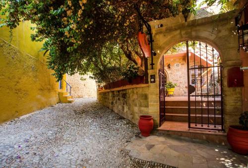 eine Gasse mit einem Eingang zu einem Gebäude mit einem Tor in der Unterkunft Attiki Hotel in Rhodos (Stadt)