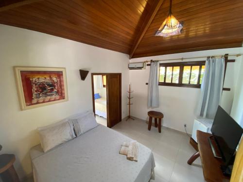 a bedroom with a bed and a television in a room at Pousada Porto da Barra in Barra Grande