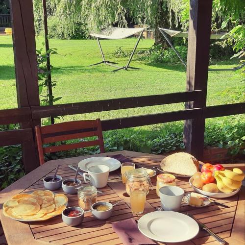 - une table en bois avec des aliments pour le petit-déjeuner et des boissons dans l'établissement Relais saint vincent, à Thonville