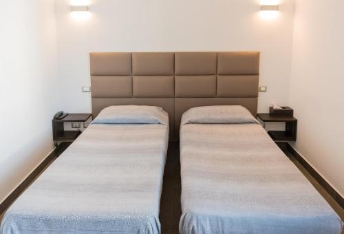 two beds in a small room with lights on at Ex-L in Fiume Veneto