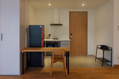 a kitchen with a wooden table and a refrigerator at Tengah Tengah in Jakarta