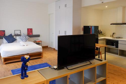 a living room with a bed and a television on a table at Tengah Tengah in Jakarta