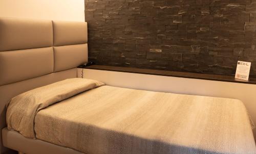 a bed in a room with a brick wall at Ex-L in Fiume Veneto