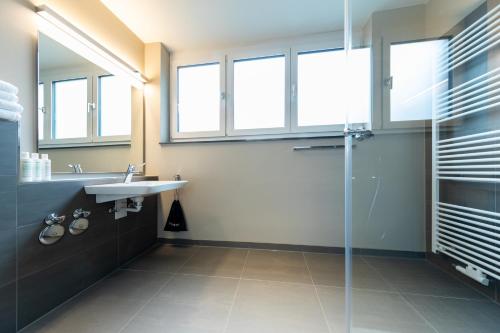a bathroom with a sink and a glass shower at Boardinghouse St.Pauli in Hamburg