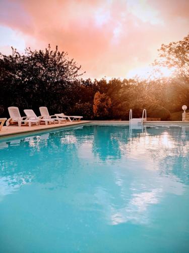 une piscine avec des chaises longues et une piscine dans l'établissement Terra Seren en Périgord, à Siorac-de-Ribérac