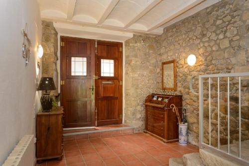 pasillo con puerta y pared de piedra en Habitación doble con baño compartido, en Bas