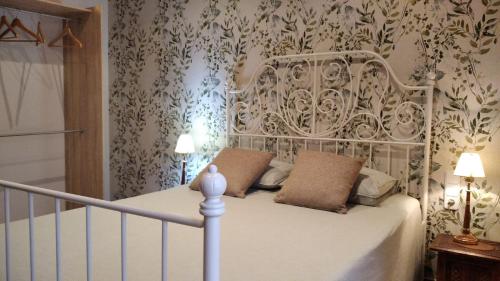 a white bed with two pillows in a bedroom at Habitación doble con baño compartido in Bas