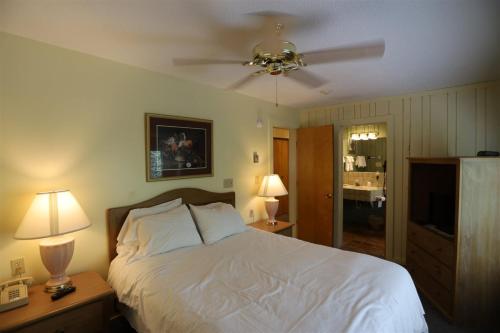 um quarto com uma cama branca e uma ventoinha de tecto em Inns Of Wv 201, 2 Bd, Waterville Valley em Waterville Valley