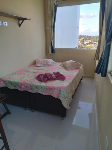 a bedroom with a bed with a pink blanket and a window at Kitnet 3,Vista Fantastica in Cabo de Santo Agostinho
