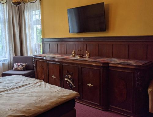 a bedroom with a sink and a tv on a wall at WeisseVilla Friedrichsbrunn Fewo EMPIRE in Thale