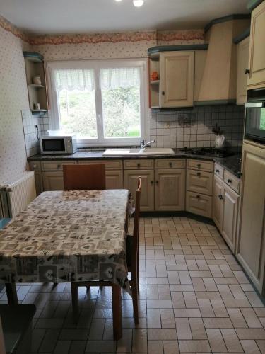 une cuisine avec une table, des chaises, une table et une fenêtre dans l'établissement La montagne, à La Bresse