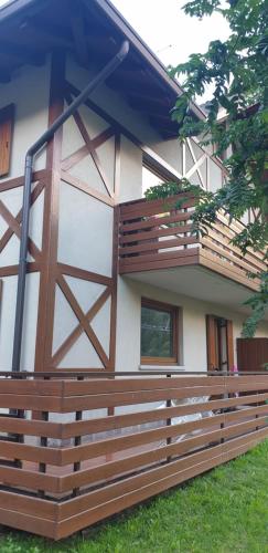 a house with a wooden fence and a barn at Il Rododendro in Ponte di Legno