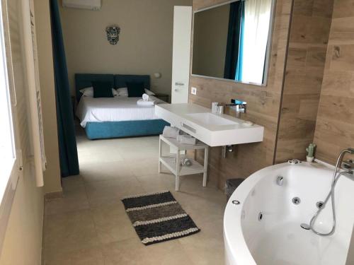 1 dormitorio con 1 cama y baño con bañera. en Villa Iiulia, en Fiumefreddo di Sicilia