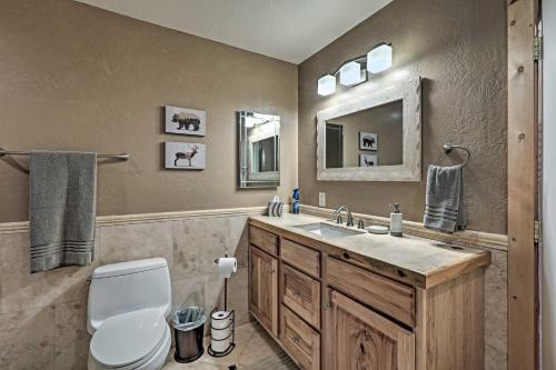 a bathroom with a sink and a toilet and a mirror at 9 Mi to Rainbow Lake Mtn Getaway with BBQ! in Pinetop-Lakeside