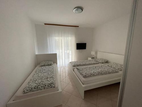 a bedroom with two beds and a television in it at Tole Villa Podaca in Podaca