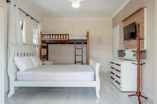1 dormitorio con 2 literas y TV en Pousada Oásis, en Peruíbe
