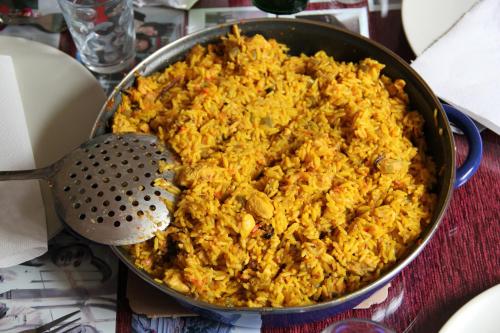 una sartén llena de arroz frito con espátula en Como en tu propia casa en Granada