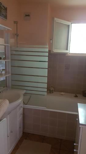 La salle de bains est pourvue d'une baignoire et d'un lavabo. dans l'établissement Joli studio de 26 m² avec véranda de 6 m² calme et vue sur montagne, à Amélie-les-Bains-Palalda