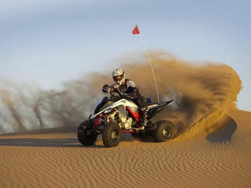 a person riding a quad bike in the desert at Excellent Desert Safari camp in Sām