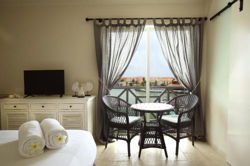 una camera da letto con un letto, un tavolo e delle sedie di Ocean Breeze Boutique Hotel & Marina a Kralendijk