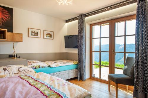 a bedroom with a bed and a tv and a window at Skyberg Chalet in Mühlbach am Hochkönig