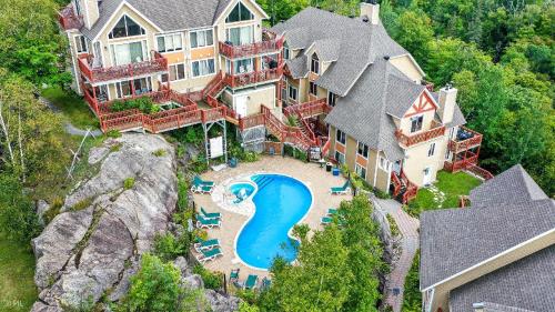 an aerial view of a large house with a swimming pool at Hauts-bois Ski Inout 2brs Wpool Access 197-4 in Mont-Tremblant