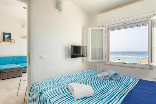 a bedroom with a bed with a view of the ocean at Appartamento fronte mare - Waterfront apartment in Putzu Idu