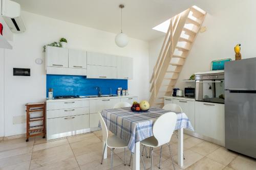 a kitchen with a table with chairs and a blue wall at Appartamento fronte mare - Waterfront apartment in Putzu Idu
