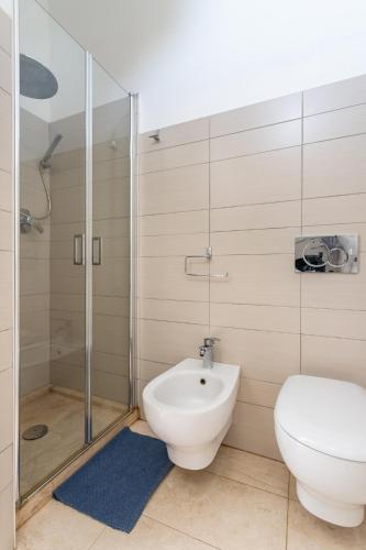 a bathroom with a toilet and a shower at Appartamento fronte mare - Waterfront apartment in Putzu Idu