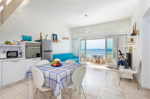 a kitchen and dining room with a table and chairs at Appartamento fronte mare - Waterfront apartment in Putzu Idu