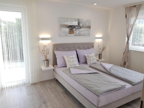 a white bedroom with a large bed with pillows at Villa Dorina in Kaštel